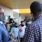 A photo of Superintendent Jones talking with staff in a school.